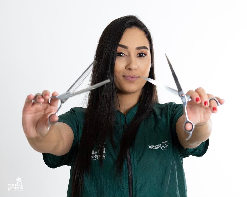 Nati, groomer therapist da Mimos da Tia Nati, segurando tesouras de tosa